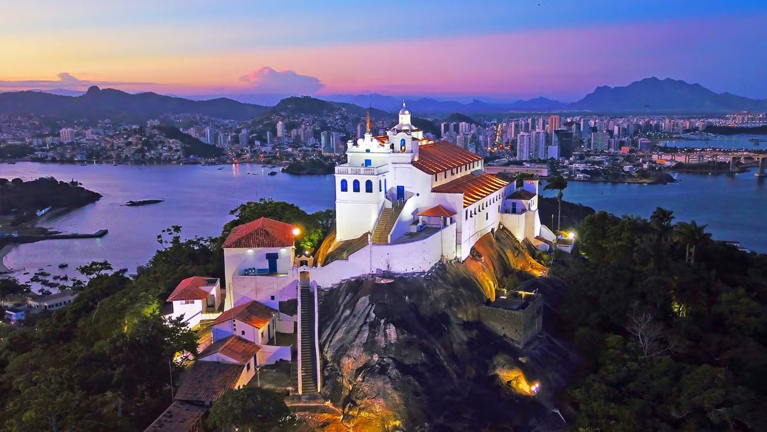 Convento da Penha ao anoitecer, com Vila Velha e Vitória ao fundo